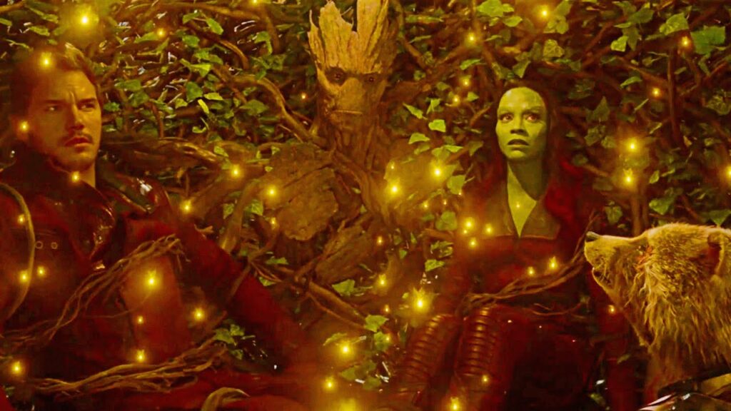A tree covering a man, a raccoon, and a green woman with its branches